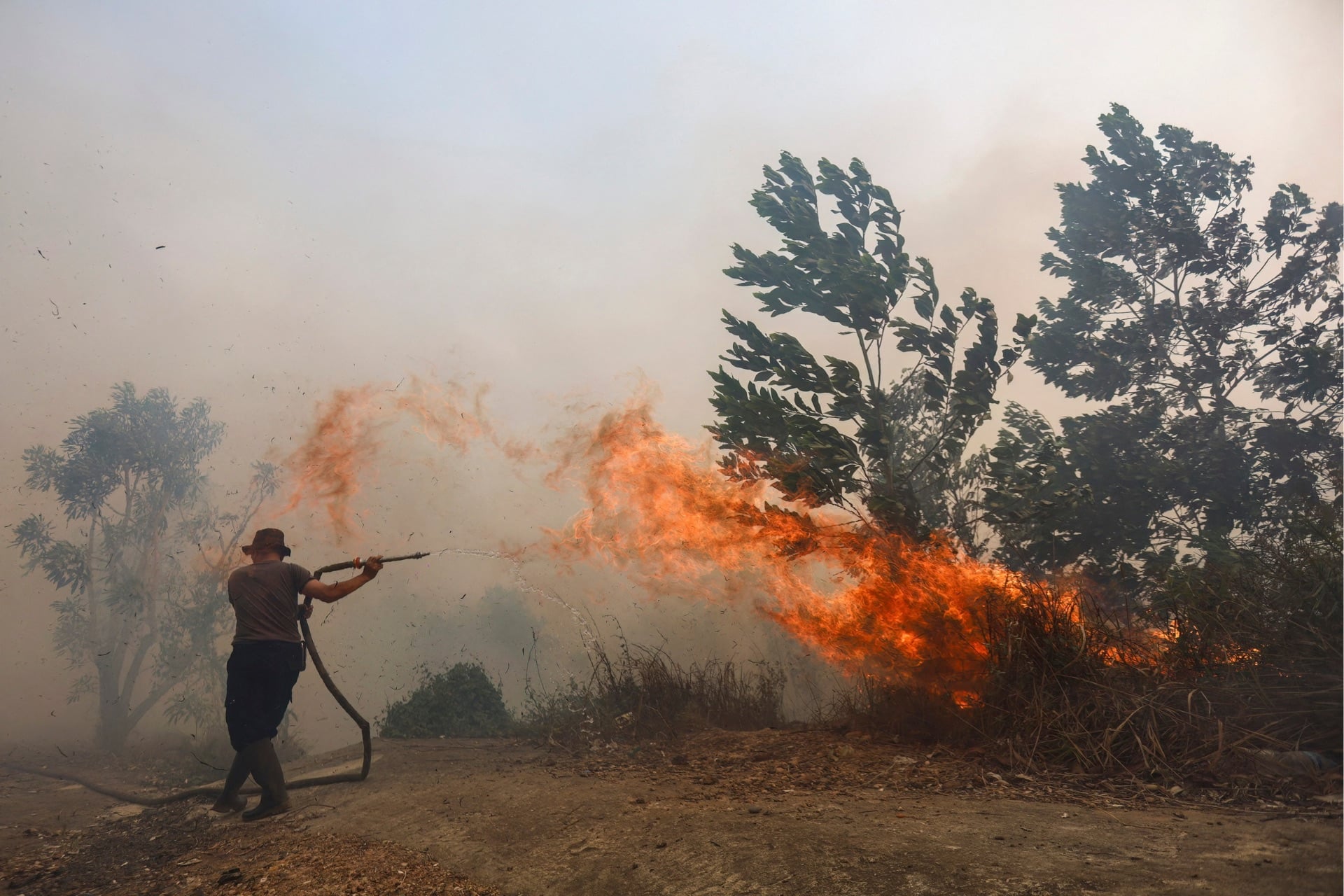 A firefighter battles a fast-moving brush fire amidst heavy smoke in South Kalimantan, Indonesia, on October 20, 2026.