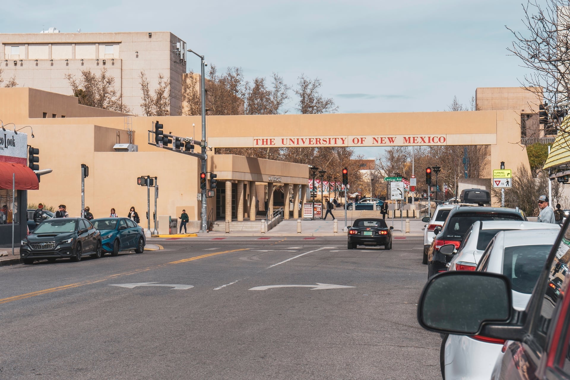 Line of cars parked outside the entrance to the University of New Mexico campus along Route 66