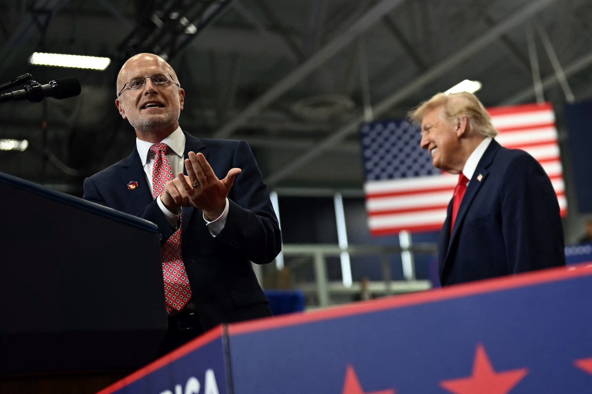 US President Donald Trump reacts as the Chairman of the Federal Communications Commission Brendan Carr speaks during a campaign rally at Curtis D. Menard Memorial Sports Center in Wasilla, Alaska, on October 13, 2026.  