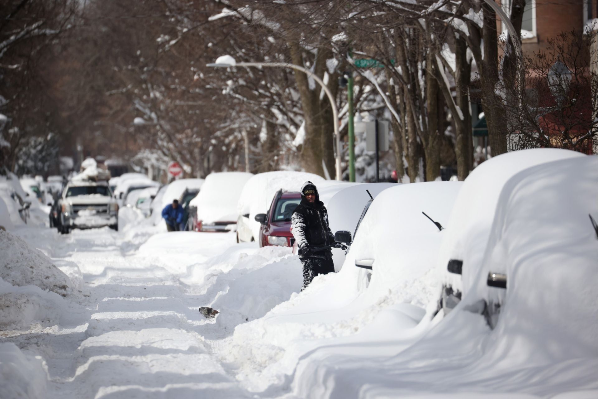 After Winter Storm Uri, people work to dig out their cars along a residential street on February 16, 2021, in Chicago, Illinois.