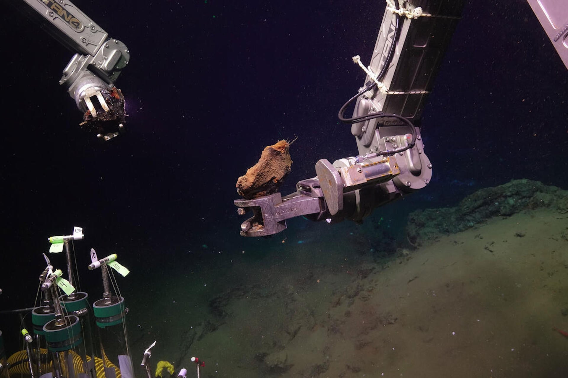 The ROV (remotely operated vehicle) Jason collecting two mineral samples from the seafloor at Escanaba Trough.