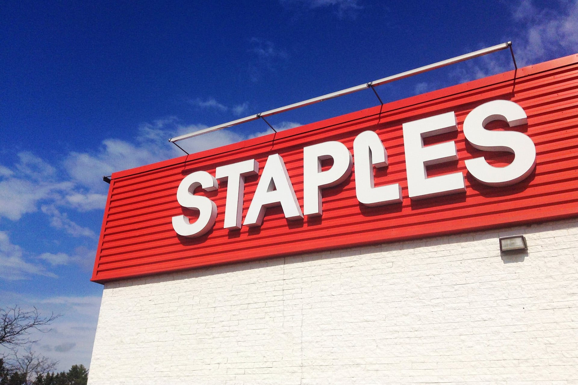 A Staples facade against a clear blue sky