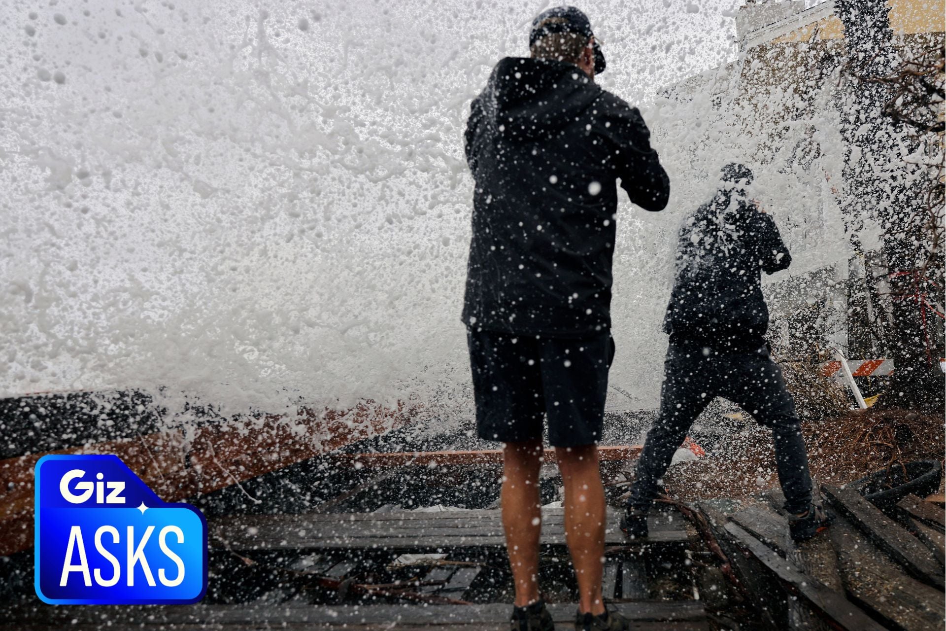 People take photos from a damaged boardwalk as a Pacific Ocean wave crashes over a seawall, amid high surf generated by Post-Tropical Storm Rachel on October 12, 2026, in Long Beach, California. 